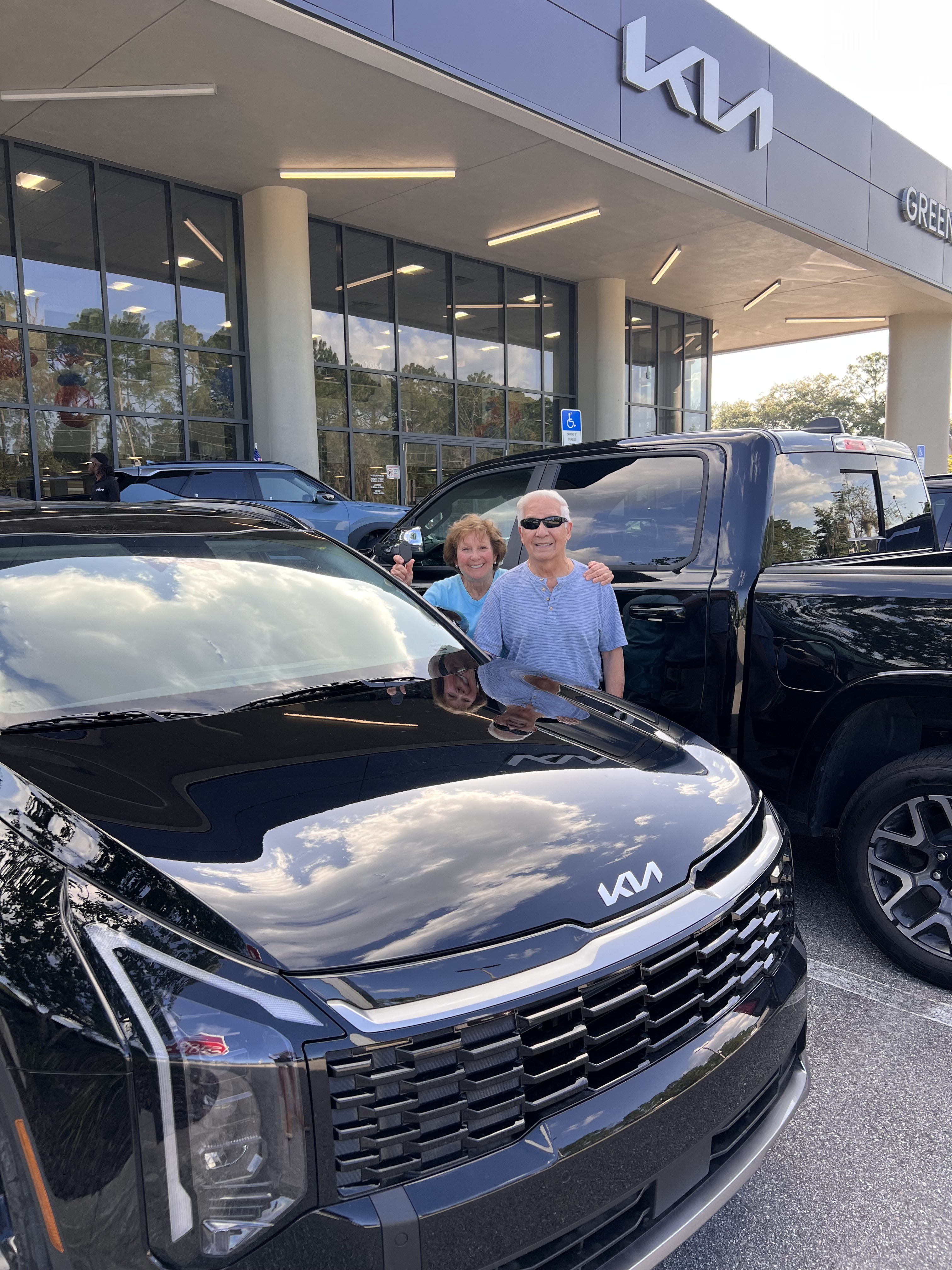 Happy clients with their new Kia Sportage Hybrid — Deal Drvn flat fee car buying service